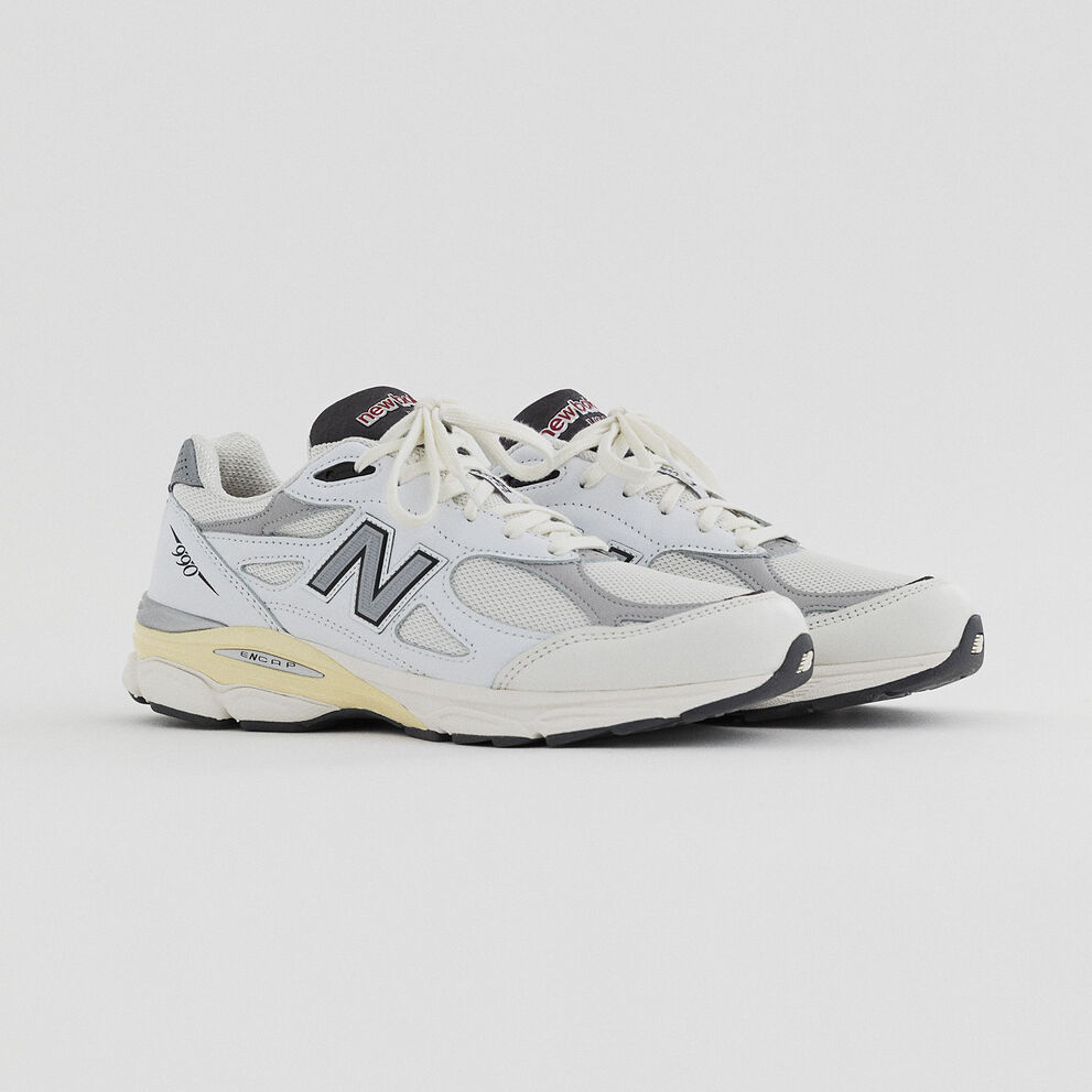 Pair of white 990v3 from the upcoming Made in USA Collection on a grey studio backdrop.