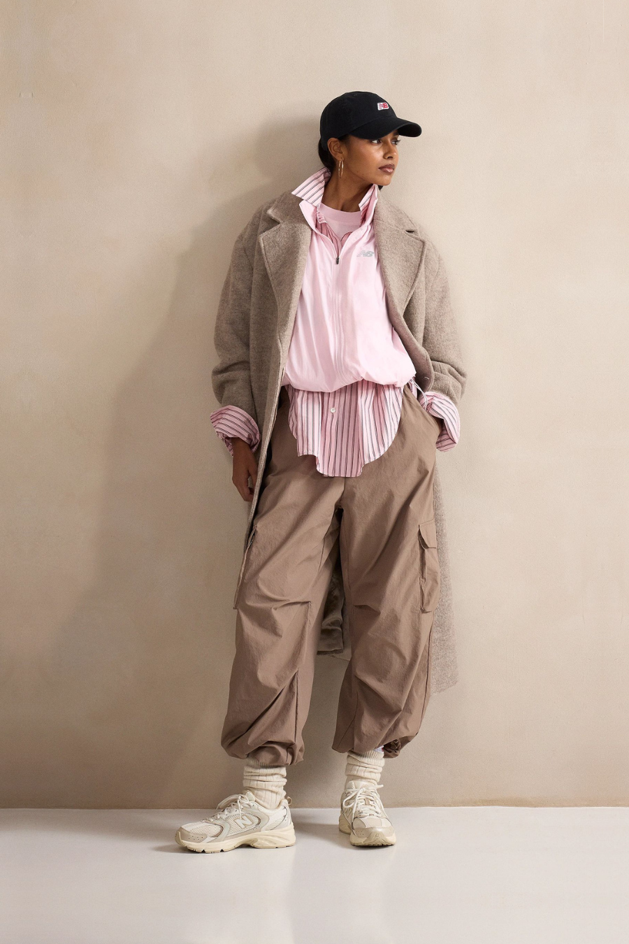 A person standing against a tan studio backdrop.