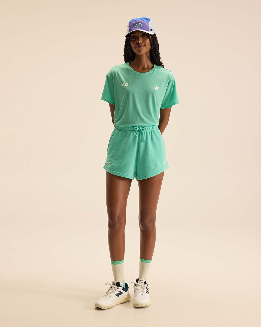 A person standing against a tan studio backdrop.